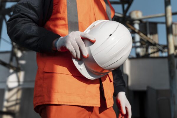 Close-up of a worker's hand holding a safety helmet, symbolizing workplace safety and workers' compensation lawyer legal representation